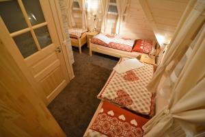 Cette petite chambre comprend 2 lits et une porte. dans l'établissement Penzión Adriana, à Demänovská Dolina
