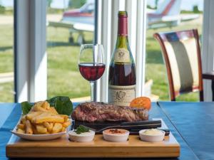 a table with a bottle of wine and a steak and french fries at Femo Kro & Feriecenter by DanCenter in Nørreby