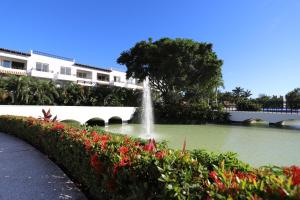 a fountain in the middle of a pond with flowers at Departamento Taheima Nuevo Vallarta in Nuevo Vallarta