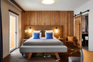a bedroom with a large bed with blue pillows at Ecrin Blanc Resort Courchevel - Aquapark in Courchevel