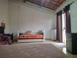 a bedroom with a bed in a room with windows at chalé casa na mata céu Iluminado in Guararema