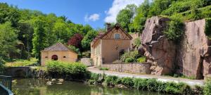 a building next to a river with a bridge at Studio de l'Armançon in Semur-en-Auxois