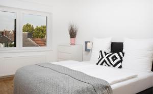 Victoria Apartments في دوسلدورف: سرير أبيض في غرفة بها نافذة