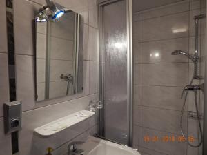 a bathroom with a shower and a sink and a mirror at Gästehaus Am Römerbad in Zell an der Mosel