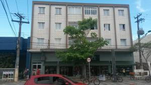 Un coche rojo aparcado delante de un edificio en Apartamento Aconchego da vovó, en Peruíbe