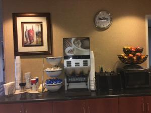 a kitchen counter with a coffee maker and a clock at Microtel Inn & Suites by Wyndham Indianapolis Airport in Indianapolis
