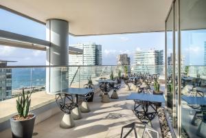 a balcony with tables and chairs on a building at Hilton Diagonal Mar Barcelona in Barcelona