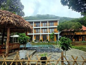 a resort with a swimming pool in front of a building at Meadow Mai Chau Homestay in Mai Châu +43 photos