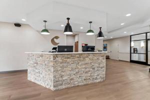 an office lobby with a stone counter and pendant lights at Comfort Suites Augusta Riverwatch in Augusta