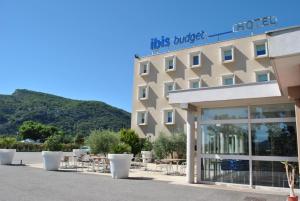 un hotel con mesas y sillas delante en ibis budget Loriol Le Pouzin, en Le Pouzin