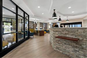 a lobby with a stone counter with chairs and tables at Comfort Suites Augusta Riverwatch in Augusta +74 photos