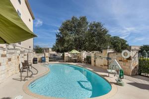 a large swimming pool with chairs and a building at Comfort Suites San Antonio North - Stone Oak in San Antonio