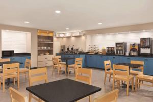 a dining room with blue cabinets and tables and chairs at Country Inn & Suites by Radisson, Dunn I-95 in Dunn
