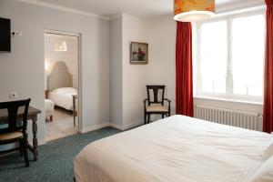 a bedroom with a bed and a desk and a mirror at Auberge du Cabestan Hotel Audierne in Audierne