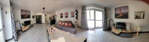 a living room with a couch and a tv at Studio de l'Armançon in Semur-en-Auxois