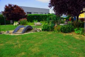 a garden with a bench in the grass at Klein und Fein in Hartberg +4 photos
