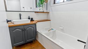 a bathroom with a sink and a bath tub at Keyside Escape in Forster +20 photos