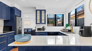 a kitchen with blue cabinets and a blue bowl on a counter at Keyside Escape in Forster
