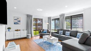a living room with a couch and a table at Keyside Escape in Forster