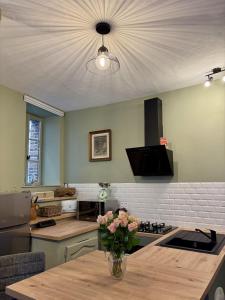 a kitchen with a vase of flowers on a table at L'Escapade Maillotine in Joigny