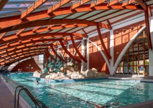 a large swimming pool with people in the water at L'Escapade Maillotine in Joigny