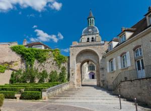 an entrance to a building with a clock tower at L'Escapade Maillotine in Joigny