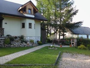 a house with a garden and a driveway at Agroturystyka Świt dobry in Strzebowiska