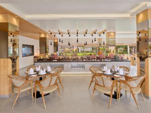 a dining room with two tables and chairs and a restaurant at Empire By Zuper in Bhopal
