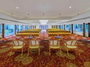 a large room with tables and chairs and windows at Empire By Zuper in Bhopal +26 photos