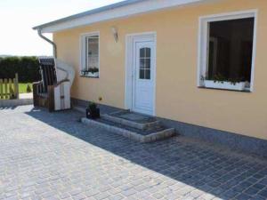 a house with a black cat sitting in front of it at Ferienhaus Ostsee Antje Bellmann in Kemnitz