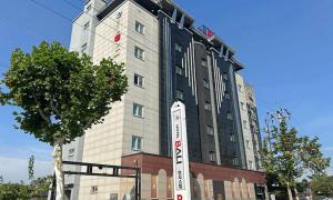 a tall building with a sign in front of it at 충주 호텔 발리 in Chungju