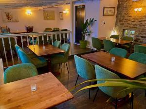a restaurant with wooden tables and green chairs at Bolton arms downholme in Richmond