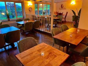 a restaurant with wooden tables and chairs and windows at Bolton arms downholme in Richmond +26 photos