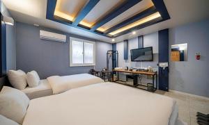 a hotel room with two beds and a television at 충주 호텔 발리 in Chungju