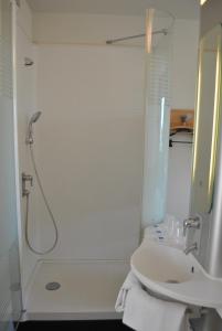 baño blanco con ducha y lavamanos en ibis budget Loriol Le Pouzin, en Le Pouzin