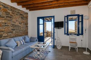 a living room with a blue couch and a brick wall at Tzados Sunny Villa in Kariá