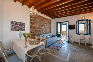 a living room with a blue couch and a table at Tzados Sunny Villa in Kariá
