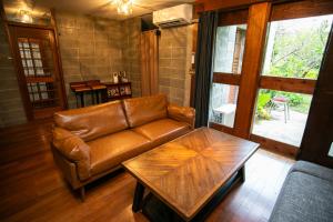 a living room with a leather couch and a coffee table at 香琉 Kaoru in Miyako-jima