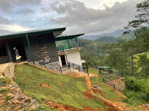 a person standing outside of a building on a hill at Stone Gale Estate Villa in Galaha Town