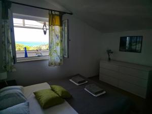 a bedroom with a bed and a window with a view at Apartman Premantura Rumora in Premantura +7 photos