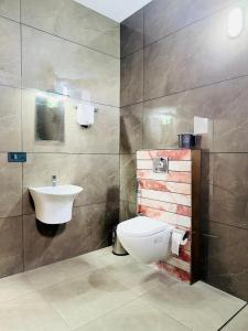 a bathroom with a toilet and a sink at River Side Paradise By Greenleaves Munnar in Anachal +27 photos