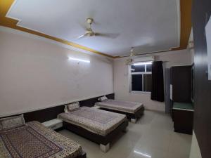 a room with three beds and a ceiling at The JANAKPURI in Ajmer