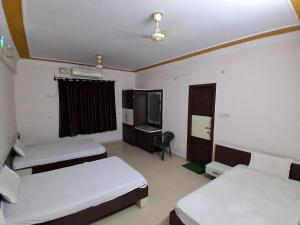 a room with two beds and a desk in it at The JANAKPURI in Ajmer +8 photos