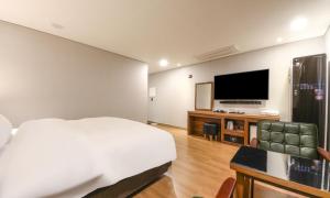 a bedroom with a bed and a flat screen tv at Anyang CNC Hotel in Anyang