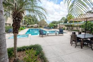 eine Terrasse mit einem Tisch und Stühlen neben einem Pool in der Unterkunft Brent House Hotel in New Orleans