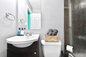 a bathroom with a sink and a toilet and a mirror at San Diego 3BR & 3BA Comfortable Home, Outdoor Kitchen, Firepit & BBQ, 10 to 15min from SeaWorld & Zoo in San Diego +37 photos