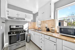 a kitchen with white cabinets and a large window at San Diego 3BR & 3BA Comfortable Home, Outdoor Kitchen, Firepit & BBQ, 10 to 15min from SeaWorld & Zoo in San Diego