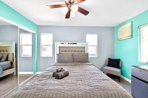 a bedroom with a large bed with a ceiling fan at San Diego 3BR & 3BA Comfortable Home, Outdoor Kitchen, Firepit & BBQ, 10 to 15min from SeaWorld & Zoo in San Diego