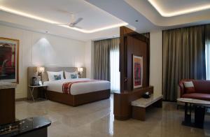 a hotel room with a bed and a couch at Wingston A TreeHouse Hotel, Mathura in Mathura +36 photos