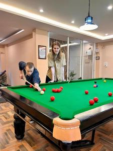 a woman and a boy playing pool on a pool table at Namaste Hostel Rishikesh in Rishīkesh